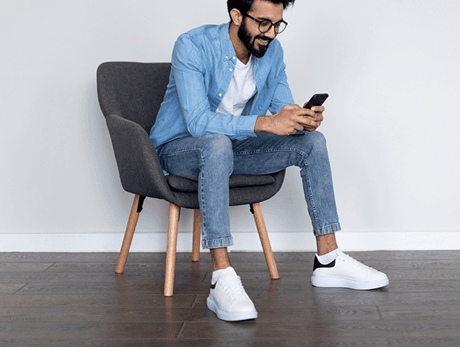 A person seating on a chair and happily using karosauda application